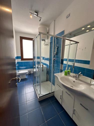 un bagno con doccia in vetro e lavandino di Gris I Blanca apartment ad Alghero