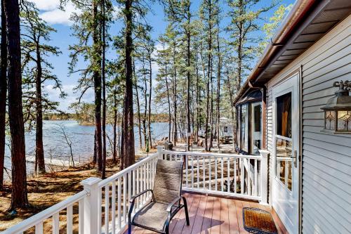 a porch with a chair and a view of the water at Main House in Ossipee