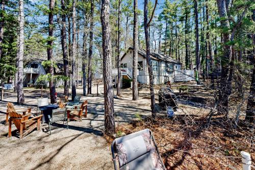 a cabin in the woods with benches and a grill at Main House in Ossipee