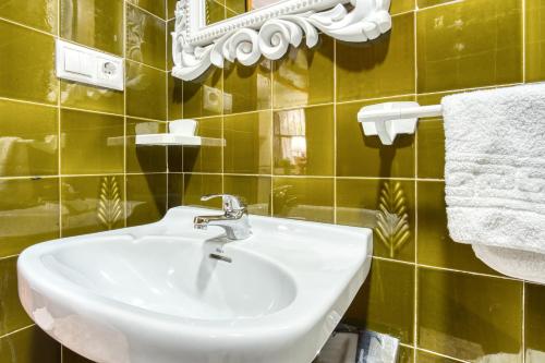 La salle de bains est pourvue d'un lavabo, d'un miroir et de serviettes. dans l'établissement Sunflower Patagonia, à Santa Pola