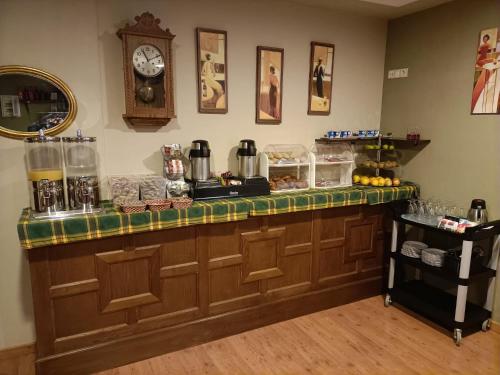 a kitchen with a counter with a clock on the wall at Hotel EO in Ribadeo