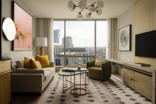 a living room with a couch and chairs and a tv at Four Seasons Hotel Toronto at Yorkville in Toronto