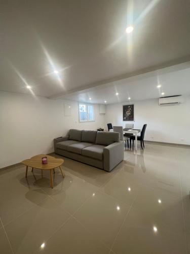 un salon avec un canapé et une table dans l'établissement Logement entier près de paris, à Deuil-la-Barre