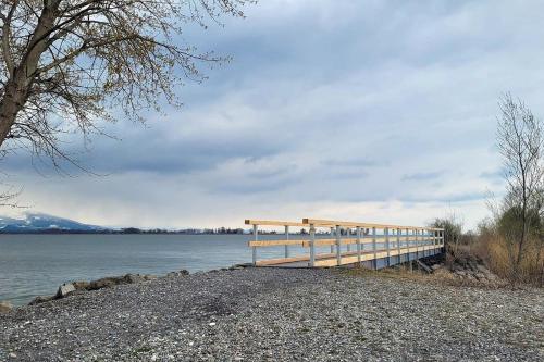 a wooden pier next to a body of water at Little Tiny Village Haus 4 in Fußach