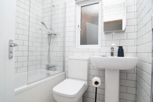 ein weißes Bad mit einem WC und einem Waschbecken in der Unterkunft Central 4bed house, free parking in Liverpool