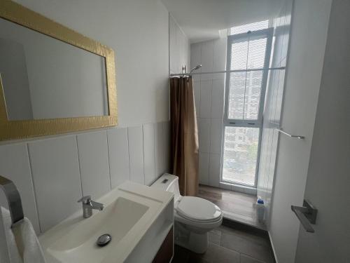 bagno con lavandino, servizi igienici e specchio di Apartamento Mónaco a Guatemala