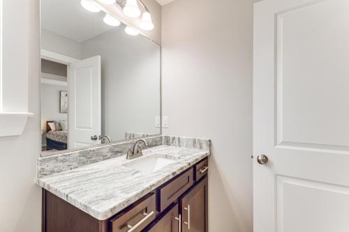 uma casa de banho com um lavatório e um espelho em Modern Virginia Beach Retreat in Resort District! em Virginia Beach