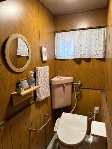 a bathroom with a toilet and a mirror at Guest House" Ro" takezaki in Amanogōchō