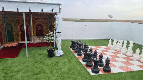 a chess board on the grass next to the water at Camping on the rooftop close to Casablanca Airport in Dah Hammou Ben Cheïkh