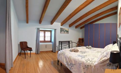 1 dormitorio con 1 cama en una habitación con suelo de madera en LA CASA DI ATHOS, en Tenna 