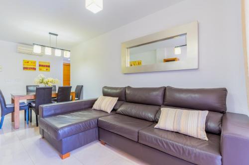 a living room with a brown leather couch and a table at Brisas Almerimar R&R in El Ejido