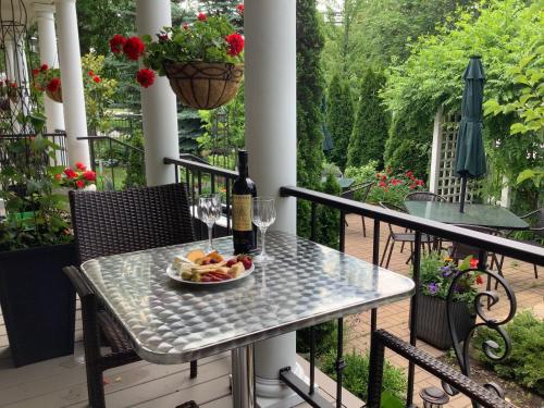 a table with a plate of fruit and a bottle of wine at Via Veneto - Old Town in Niagara-on-the-Lake