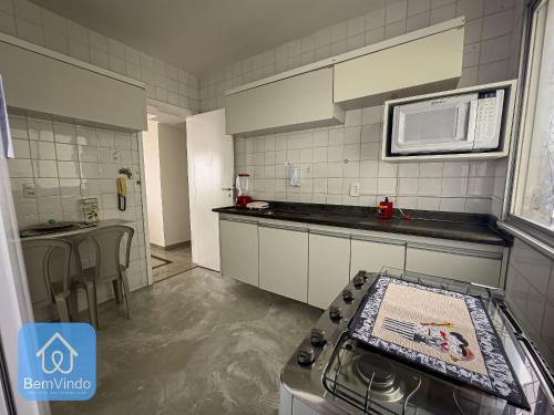 a kitchen with a stove and a microwave at Apartamento 2/4 completo e aconchegante em Salvador in Salvador