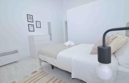 - une chambre blanche avec un lit et une lampe dans l'établissement El apartamento de San Cisneros by Just-Room, à Santander