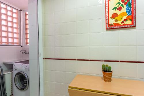 a laundry room with a washing machine and a table at Brisas Almerimar R&R in El Ejido