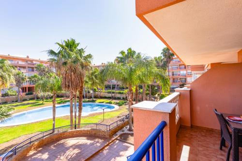 a balcony with a view of a pool and palm trees at Brisas Almerimar R&R in El Ejido