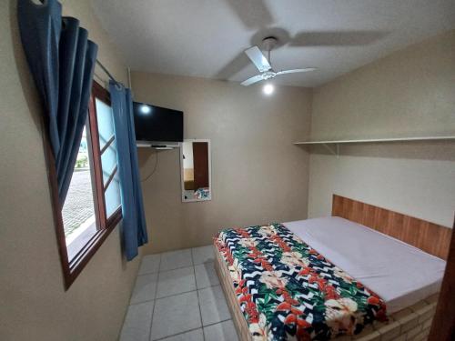 1 dormitorio con 1 cama y ventilador de techo en Pousada Belas Praia da Riba en Imbituba