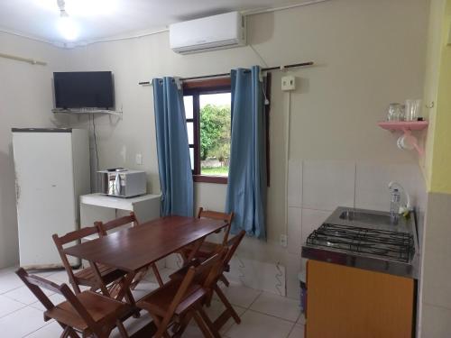 因比圖巴的住宿－Pousada Belas Praia da Riba，厨房配有桌椅和炉灶。
