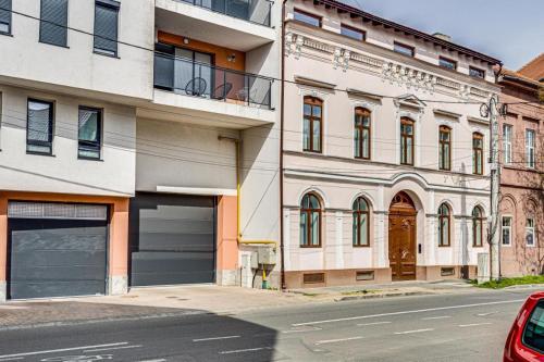 a building with two garage doors on a street at ARI Central Grand Apartments - Luxurious Stay in Arad