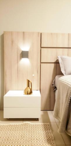 1 dormitorio con 1 cama y lavamanos con lámpara en LIGHT - Apartamento Inteiro com Ar condicionado no Parque Alvorada, en Dourados
