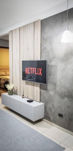 un televisor en una pared con un cartel de netflix en él en LIGHT - Apartamento Inteiro com Ar condicionado no Parque Alvorada, en Dourados