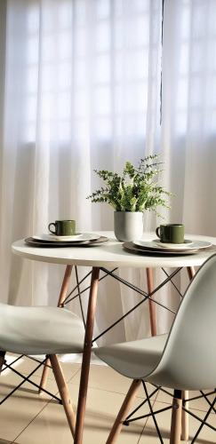 una mesa con dos platos y una planta en ella en LIGHT - Apartamento Inteiro com Ar condicionado no Parque Alvorada, en Dourados