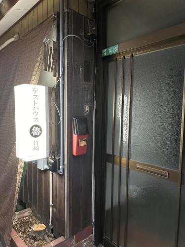 a door to a building with a sign on it at Guest House" Ro" takezaki in Amanogōchō