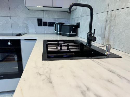 a kitchen with a sink and a stove at Luxury Hot Tub Retreat Derry City in Derry Londonderry