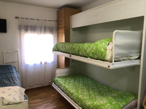 two bunk beds in a room with a window at Apartamento en Baqueira a 100 metros de la telecabina in Naut Aran