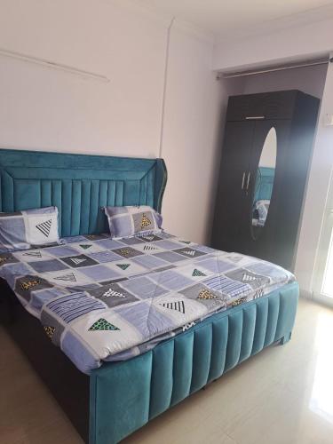 a bedroom with a blue bed with a blue comforter at 2Bhk fully furnished flat. in Ghaziabad