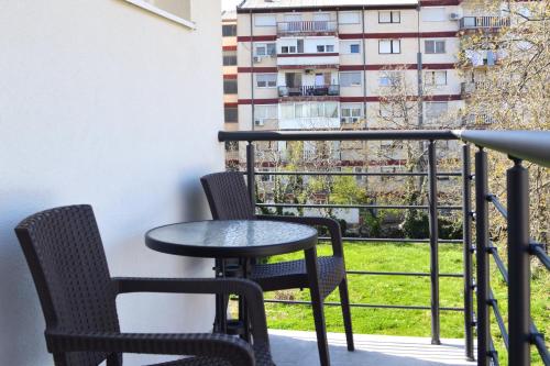 a table and chairs on a balcony with a view of a building at Villa Planta in Ohrid