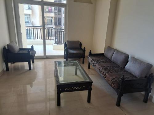 a living room with a couch and a table and chairs at 2Bhk fully furnished flat. in Ghaziabad