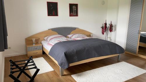 Schlafzimmer mit einem großen Bett mit einem Kopfteil aus Holz in der Unterkunft Lisa's Ferienwohnung in Obing