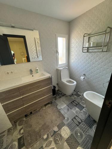 a bathroom with a sink and a toilet and a mirror at Casa Estrella Gandia in Gandía