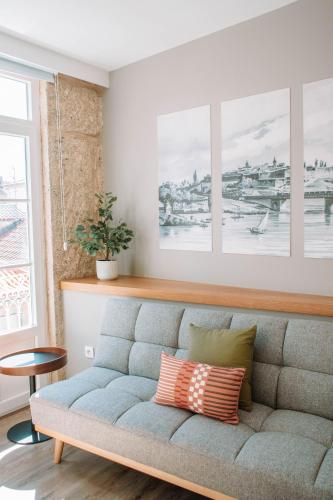 a living room with a couch with two pillows at Just Like Home - Vilavelha Suites in Valença