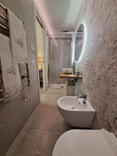 a bathroom with a white toilet and a sink at MÃE Apulian Rooms in Grottaglie