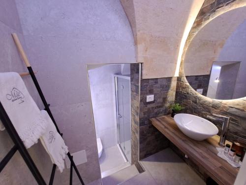 a bathroom with a sink and a mirror at MÃE Apulian Rooms in Grottaglie