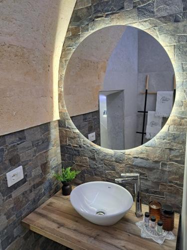a bathroom with a white sink and a mirror at MÃE Apulian Rooms in Grottaglie