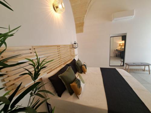 a bedroom with a large bed with pillows at MÃE Apulian Rooms in Grottaglie