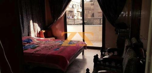 1 dormitorio con cama roja y ventana en LH HOUSE, en Amán
