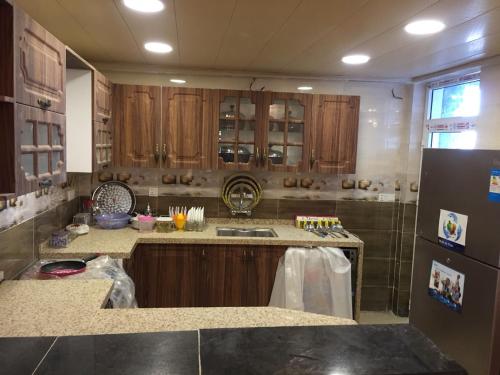 uma cozinha com armários de madeira, um lavatório e um frigorífico em LH HOUSE em Amã