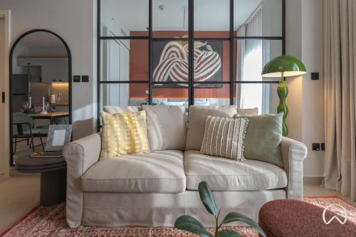 a living room with a white couch with pillows at Oraya - Collective 2 0 Tower A Sanctuary in Dubai Hills in Dubai
