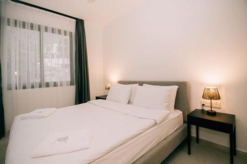 a bedroom with a large white bed and a window at Dreamview Suite Ftericha in Kyrenia