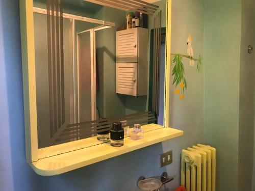 baño con espejo, lavabo y radiador en Spacious house with private garden in Chianti, en Lucolena in Chianti