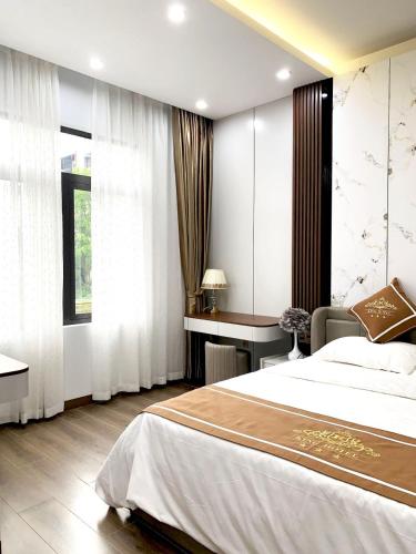 a bedroom with a bed and a desk and a window at KING HOTEL in Ha Long