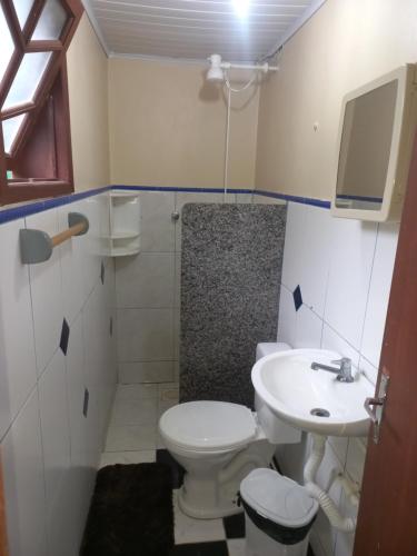 a bathroom with a toilet and a sink at Pousada Belas Praia quarto Praia dos amores in Imbituba