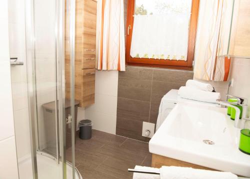 y baño con ducha y lavamanos. en Ferienwohnungen Hecher, en Feldkirchen in Kärnten