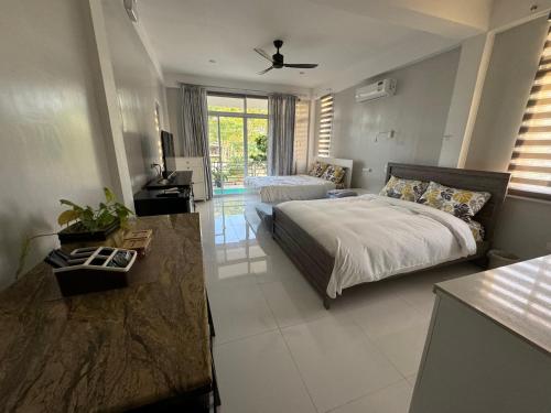 een grote slaapkamer met een bed en een bank bij INATO SUITES Rm 2 2 queen beds in Panglao