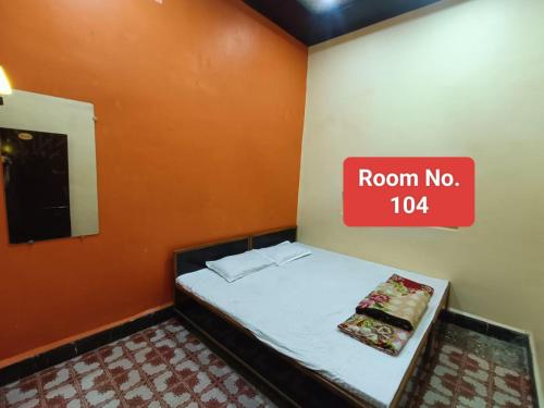 a room with a bed with a red sign on the wall at Agrawal guest house in Ujjain