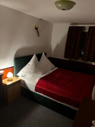 um quarto com uma cama com um cobertor vermelho em Gasthof Stern Asteri em Frickenhausen